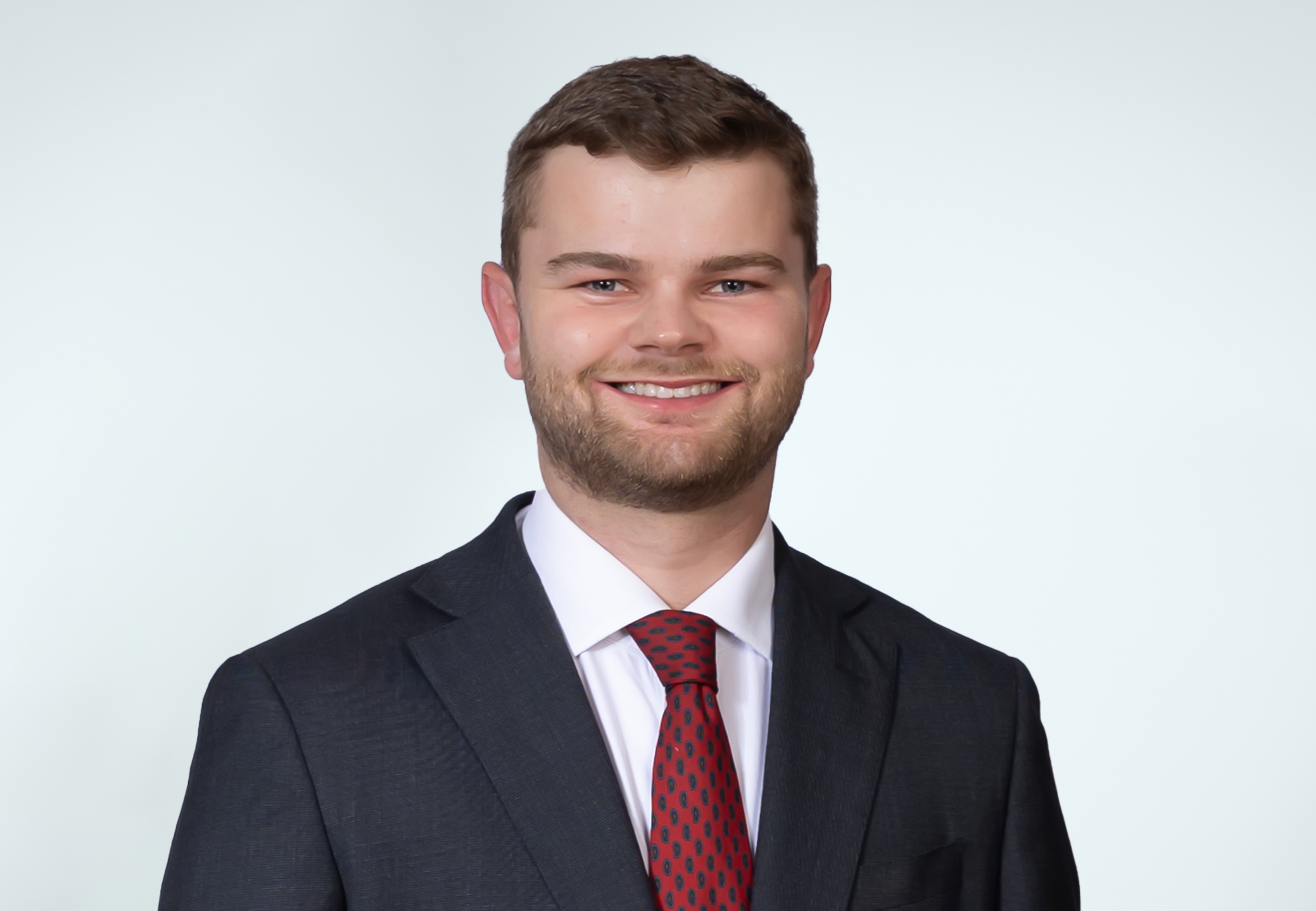 Milo Brooks wearing a dark suit and tie